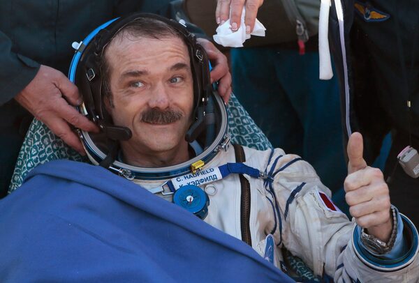 Canadian astronaut Chris Hadfield gestures with a thumbs up after the Russian Soyuz space capsule landed some 150 km (90 miles) southeast of the town of Zhezkazgan, in central Kazakhstan May 14, 2013. The first Canadian astronaut to command the International Space Station (ISS) landed safely in Kazakhstan with two crewmates on Tuesday, wrapping up a five-month mission aboard the ISS. REUTERS/Mikhail Metzel/Pool (KAZAKHSTAN - Tags: TRANSPORT SCIENCE TECHNOLOGY)