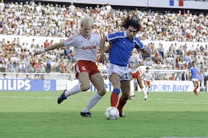 French soccer player Dominique Rocheteau tries to protect the ball from Canadian Ian Bridge during the first half of the group C World Cup opening game, 01 June 1986 in Mexico. (Photo credit should read STAFF/AFP via Getty Images)