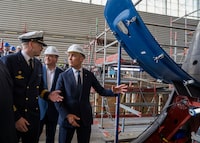 Prime Minister Mark Carney, right, and TKMS CEO Oliver Burkhard, centre, tour a submarine-building facility in Kiel, Germany, in August, 2025.