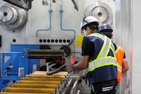 FILE PHOTO: An aluminum extrusion is pulled by workers into a clamp at Magna Aluminum Profile in Salaberry de Valleyfield, Quebec, Canada, June 11, 2025. REUTERS/Evan Buhler/File Photo