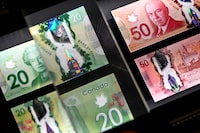 A magnifying glass enlarges the holographic image of Parliament Hill's Peace Tower on a 20 dollar bill issued by the Bank of Canada, shown in a display case at the Bank of Canada Museum in Ottawa, on Wednesday, Sept. 4, 2024. The Bank of Canada says Canadians were keeping more cash on hand in 2024. THE CANADIAN PRESS/Justin Tang