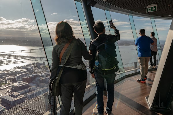 Tourists look out over Auckland from the Sky Tower.