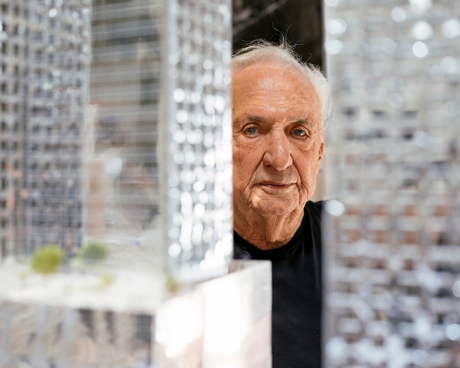 Frank Gehry looks out from behind a model of the King Street project in his native Toronto, at his Los Angeles architecture studio, in April, 2021.