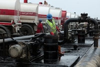 FILE PHOTO: Men work during the unloading of oil from trucks arriving from Iraq at the Baniyas oil terminal, in Baniyas, Syria, May 14, 2026.  REUTERS/Mahmoud Hassano/File Photo