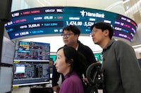 Currency traders watch monitors near a screen showing the Korea Composite Stock Price Index (KOSPI), top center, and the foreign exchange rate between U.S. dollar and South Korean won, top center left, at the foreign exchange dealing room of the Hana Bank headquarters in Seoul, South Korea, Friday, March 6, 2026.  