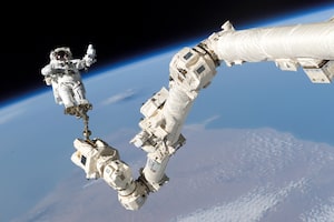 2005-08-03 - Mission STS-114 was known as “The Return to Flight,” being the first shuttle launch since the Columbia tragedy. Among its many tasks, Canadarm2 assisted astronauts during their spacewalks. In this image, NASA astronaut Stephen Robinson is held aloft by Canadarm2 during the crew’s third spacewalk. (Credit: NASA)