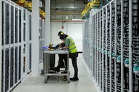 Microsoft employees work on decommissioning server racks in the Microsoft cloud data hall in the Microsoft data centre, during an announcement on Microsoft's global energy strategy, regarding how it procures and manages energy to scale AI and digital infrastructure sustainably, in Dublin, Ireland, February 17, 2026. REUTERS/Clodagh Kilcoyne