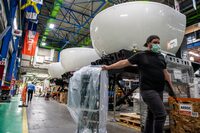 A man pulls a ventilator by the exterior of a CAE flight simulator during a press tour at the CAE factory in Montreal, Que. on Aug. 12, 2020.