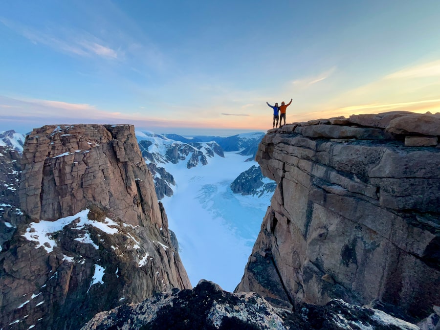 Niall McCann and brother Finn McCann embrace after reaching the summit of Mount Asgard.