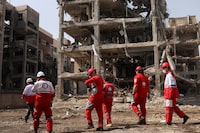 A Red Crescent rescue team works next to a building that was damaged by a strike, amid the U.S.-Israeli conflict with Iran, in Tehran on Tuesday.