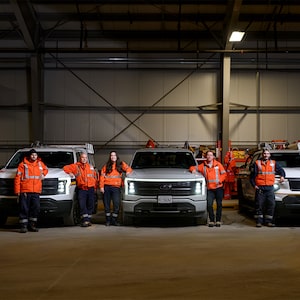 Members of the systems operations group at Hydro Ottawa stand next to the electric vehicle fleet.