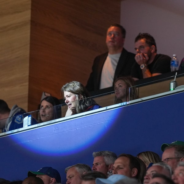 While the spotlight shines on Alberta Premier Danielle Smith at a Vancouver NHL playoff game last year, Sam Mraiche, at top centre right with his hand under his chin, watches the Oilers and Canucks play. Mr. Mraiche now faces questions about his medical-supply company's dealings with the province’s health authority.