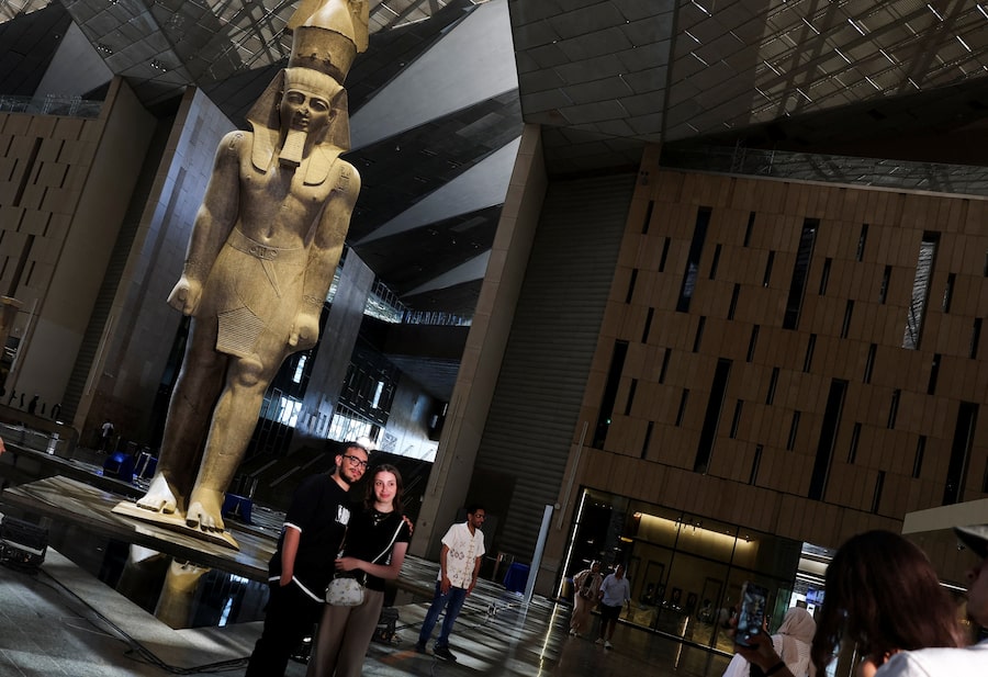 This statue of Ramses II, a pharaoh who ruled Egypt more than 3,200 years ago, towers over all who visit the Grand Egyptian Museum in Giza. These visitors got to see it for a limited opening in June, but the site officially opens to the public on Nov. 1.