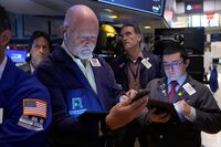 Robert Moran, left, works with fellow traders on the floor of the New York Stock Exchange, Friday, Aug. 16.