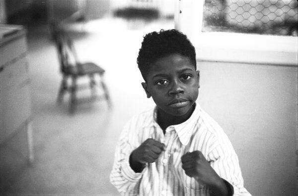 A young boy with fists clenched in boxing pose - like a young "Joe Louis".  Credit: George Zimbel