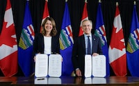 Prime Minister Mark Carney, right, signs an MOU with Alberta Premier Danielle Smith in Calgary, Alta., Thursday, Nov. 27, 2025. THE CANADIAN PRESS/Jeff McIntosh