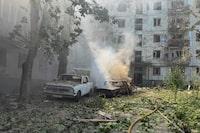 This photograph shows burned cars next to a damaged residential building at the site of a Russian air strike in Zaporizhzhia, Monday.
