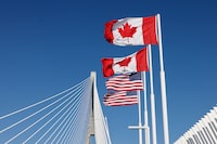 Flags of Canada and United States fly across the international border on the Gordie Howe International bridge that connects Windsor, Ontario,  Canada and Detroit, Michigan on September 6, 2026. Canada announced on August 25, 2026 counter-tariffs on US goods ranging between 15 and 50 percent, intensifying the trade war between the historically close allies. Ottawa's retaliation will take effect September 8, a timeframe earlier outlined by Prime Minister Mark Carney after US President Donald Trump's 50-percent duties came into place August 22, 2026. (Photo by JEFF KOWALSKY / AFP via Getty Images)