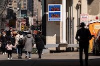 People walk past a sign showing the gas price at a gas station, Tuesday, March 10, 2026, in New York. (AP Photo/Yuki Iwamura)