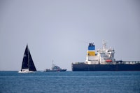 A French Maritime Gendarmerie boat patrols around the Mozambique-flagged oil tanker named Deyna, which France says is part of Russia's shadow fleet, off the port of Marseille-Fos in the Gulf of Fos-sur-Mer, near Martigues, France, March 23, 2026. REUTERS/Manon Cruz