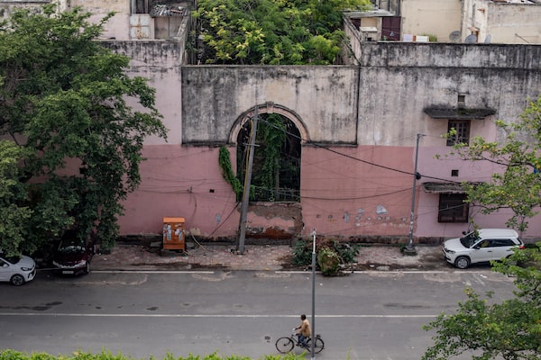 A man cycles along a street in central New Delhi on September 24, 2023. Many older buildings in the Indian capital used asbestos in their construction.