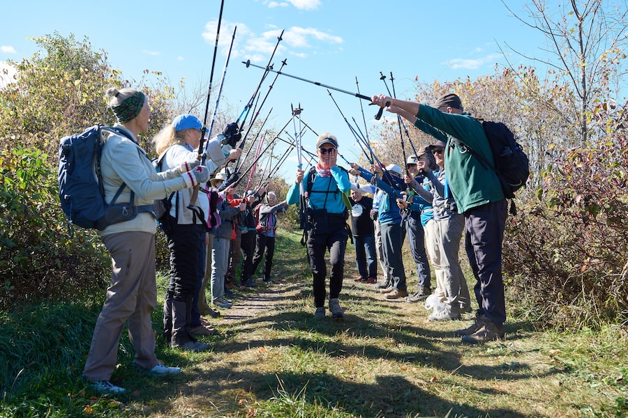 Rita Hotchkiss, 84, begins crying as she runs beneath the poles of her fellow hikers, commemorating the end of her two-and-a-half year journey of completing the Bruce Trail.
