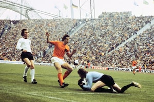 (FILES) West German goalkeeper Sepp Maier catches the ball in front of Dutch forward Johan Cruyff as defender Franz Beckenbauer (L) looks on, on July 7, 1974 in Munich, during the World Cup soccer final. Host West Germany beat The Netherlands 2-1 to earn its second World Cup title, twenty years after its first win over Hungary (3-2), 04 July 1954 in Bern. From the pioneers of the 1930 tournament to Lionel Messi's coronation in 2022, by the artistry of King Pele and the complex legacy of Diego Maradona, the Football World Cup is rich with great and small stories leading up to the 2026 edition in the United States, Canada, and Mexico. (Photo by AFP via Getty Images)