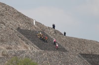 Forensic workers remove a victim's body from a pyramid after authorities said a gunman opened fire in Teotihuacan, Mexico, Monday, April 20, 2026. (AP Photo/Eduardo Verdugo)