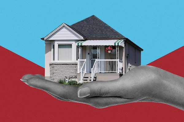 A large hand holds a bungalow house