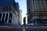 A person walks by an under-construction condo and mixed use development at Bloor and Dufferin streets in Toronto's west end on Thursday, December 4, 2025.  (Cole Burston/The Globe and Mail)