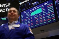 A trader reacts at the New York Stock Exchange under a screen showing the Dow Jones Industrial Average (DJI), at the end of the trading day, in New York City, U.S., November 6, 2024.  