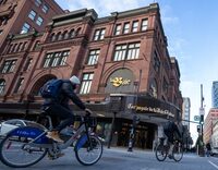 People cycle past the Hudson's Bay department store in downtown Montreal on Monday, March 17, 2025.