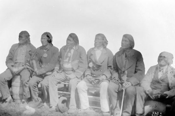 Chief Henry Prince, Councillors and interpreter, St. Peters [St. Peter's], Manitoba, 1880. In 1871, Henry Prince, son of  Chief Peguis, had signed Treaty 1 on behalf of the St. Peter's Band, (later the Peguis First Nation). Credit: Robert Bell / Library and Archives Canada

NB: St. Peter’s was a community of Cree and Saulteaux peoples in the Red River Valley, in what is today southern Manitoba. A band of Swampy Crees, led by Chief Peguis, and Saulteaux peoples established the community as an agricultural settlement in the early nineteenth century. The missionary John Cockran set up an Anglican parish and church, called St. Peter’s, for Peguis’s band in the 1830s, and it is from here that the community got its name. St. Peter’s parish and its associated mission village has often been used interchangeably to describe the larger Indigenous community along this stretch of the Red River. As white settlement continued to grow in the Red River valley, and with the 1869-70 conflict over territory between Métis and the Dominion Government, the Cree and Saulteaux sought a formal treaty with the Canadian Government. The government agreed to do so in 1871. With Treaty 1 the government recognized what was then mostly Saulteaux and Swampy Cree territory in the Red River Valley as an Indian Reserve and promised to protect it. St. Peter’s became a thriving agricultural settlement with its Indigenous inhabitants cultivating over 2,000 acres of land by the late 1870s. Despite this agricultural success, the government and white settlers accused St. Peter’s Indigenous farmers as being insufficiently productive and in 1908 the Department of Indian Affairs closed the St. Peter’s Reserve. Most of its inhabitants were compelled to leave the region and move north to establish a new reserve on the Fisher River, as the Peguis First Nation.