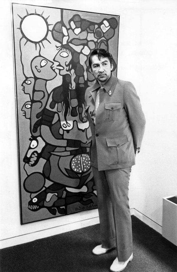 Canadian artist Norval Morrisseau with his painting, Mother Earth, at the Pollock Gallery, August 18, 1975. Photo by James Lewcun / The Globe and Mail