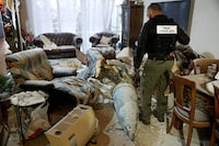 A member of the Israeli police inspects part of an Iranian missile in a living room in Rehovot, Israel on Friday.