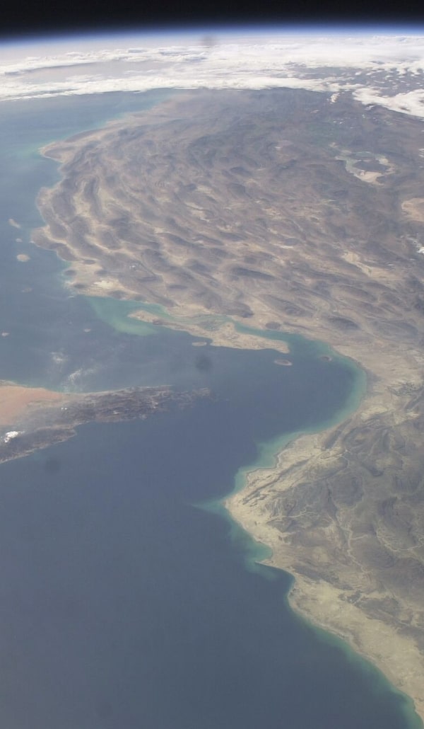 Between the Persian Gulf, top left, and the Gulf of Oman, bottom, is the narrow Strait of Hormuz. Ships could cross it more freely when the International Space Station took this photo in 2003, but recently, war between the United States, Israel and Iran has hobbled sea traffic through it.