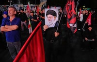 A man holds a poster of the late Iranian Supreme Leader Ayatollah Ali Khamenei in a gathering commemorating him at a square in Tehran, on Saturday.