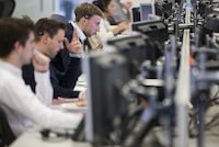 FILE PHOTO: Dealers work on the IG Group trading floor in London, Britain June 30, 2015. REUTERS/Neil Hall/File Photo