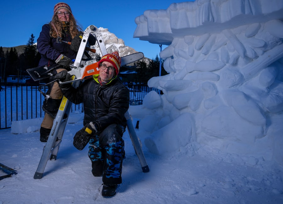 Dawn Detarando and Brian McArthur pose next to their sculpture, The Industrious Beaver: Environmental Superhero, in Banff, Alta., in January. The pair have sculpted snow across the country for more than two decades.