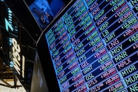 A board above the trading floor of the New York Stock Exchange with stock symbols is shown in this image, Tuesday, July 1, 2025. (AP Photo/Richard Drew)