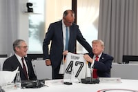 U.S. President Donald Trump, right, holds up a jersey with the number 47 on it as British Prime Minister Keir Starmer, left, and German Chancellor Friedrich Merz look on during a working session at the G7 summit in Evian-les-Bains, France, Tuesday, June 16, 2026. (AP Photo/Thibault Camus, Pool)