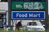 A gas station attendant fills a customer's tank at a gas station on Friday, April 17, 2026, in Portland, Ore. (AP Photo/Jenny Kane)