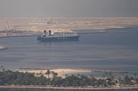 A cargo ship is seen leaving the Dubai port, United Arab Emirates, on Sunday.
