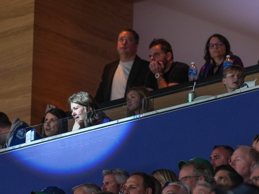 While the spotlight shines on Alberta Premier Danielle Smith at a Vancouver NHL playoff game last year, Sam Mraiche, at top centre right with his hand under his chin, watches the Oilers and Canucks play. Mr. Mraiche now faces questions about his medical-supply company's dealings with the province’s health authority.
