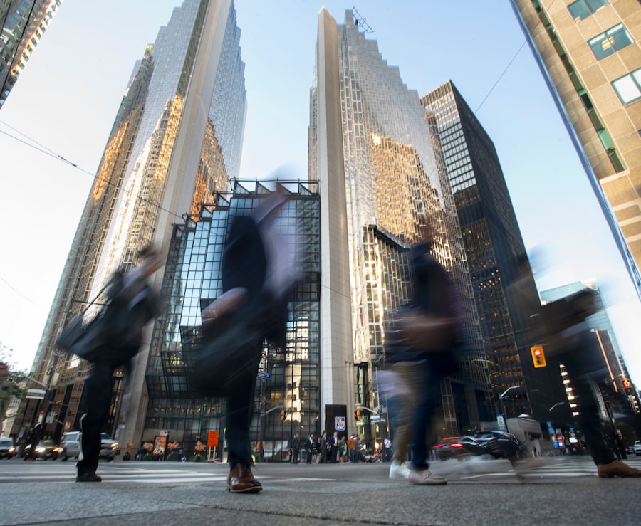 Pedestrians pass Royal Bank Plaza in Toronto’s financial district during the weekday morning commute.
