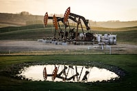 Pumpjacks draw out oil and gas from a wellhead near Calgary.
