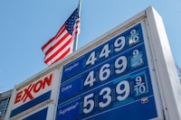 Gas prices are displayed at an Exxon station near a U.S. flag, amid the U.S.-Israeli conflict with Iran, in Washington, D.C., U.S., March 10, 2026. REUTERS/Kylie Cooper