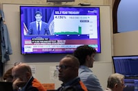 NEW YORK, NEW YORK - JUNE 17: A television displays a Kevin Warsh, chairman of the Federal Reserve, press conference as traders work on the floor of the New York Stock Exchange during afternoon trading on June 17, 2026 in New York City. Warsh spoke about the Federal Reserve decision to keep key rate unchanged for the fourth time this year.  (Photo by Michael M. Santiago/Getty Images)