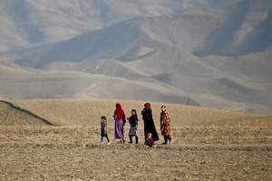 Afghan women and children walk along the foothills on the outskirts of Fayzabad district in Afghanistan's Badakhshan province on July 27, 2026. (Photo by Wakil Kohsar / AFP via Getty Images)