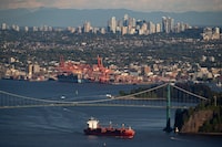 A container ship passes under the Lions Gate Bridge after leaving port, in Vancouver, Monday, May 18, 2020. THE CANADIAN PRESS/Darryl Dyck
